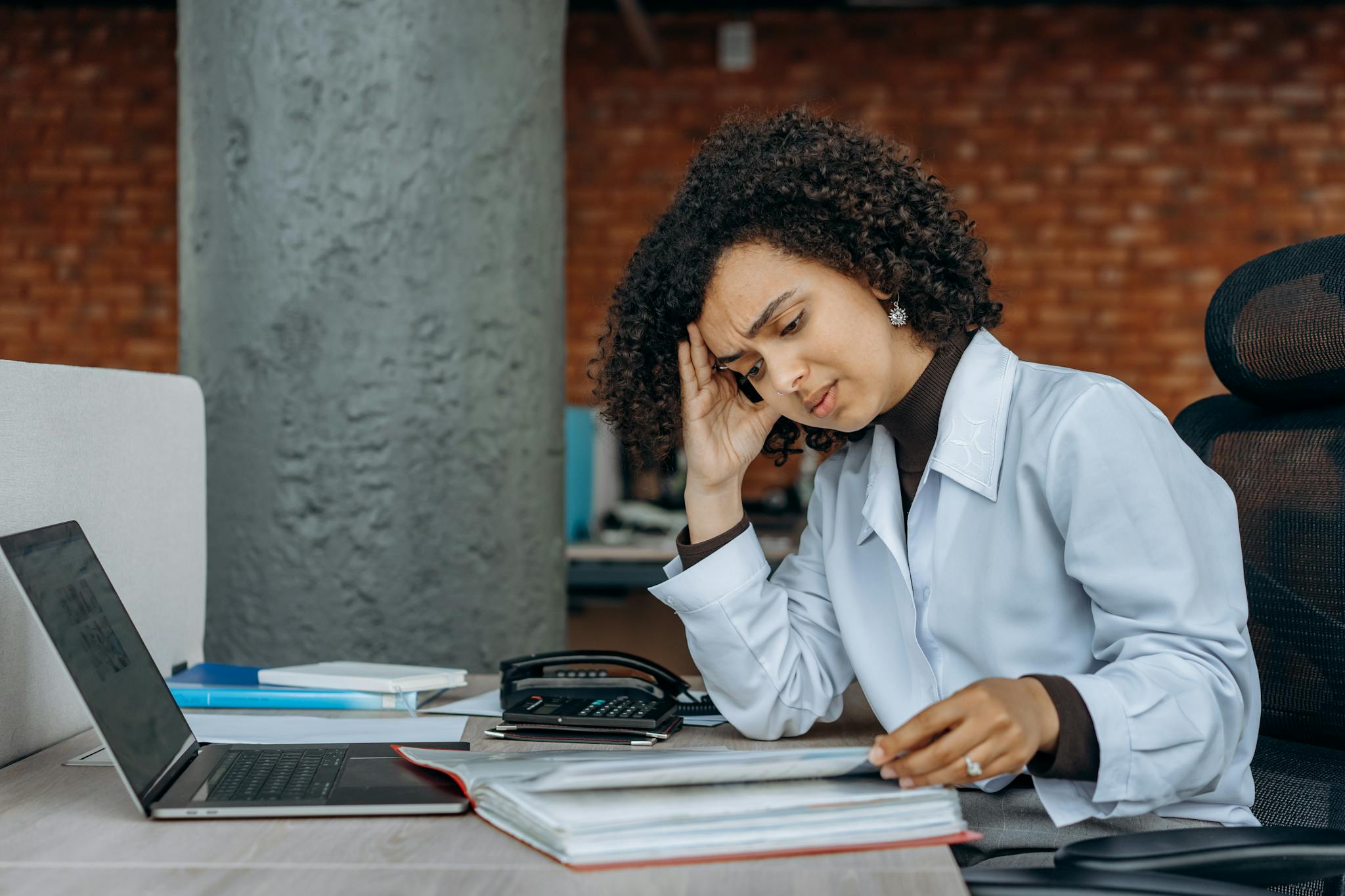 Zesty for Accountants 5 Businesswoman experiencing fatigue while working on financial paperwork at her desk.