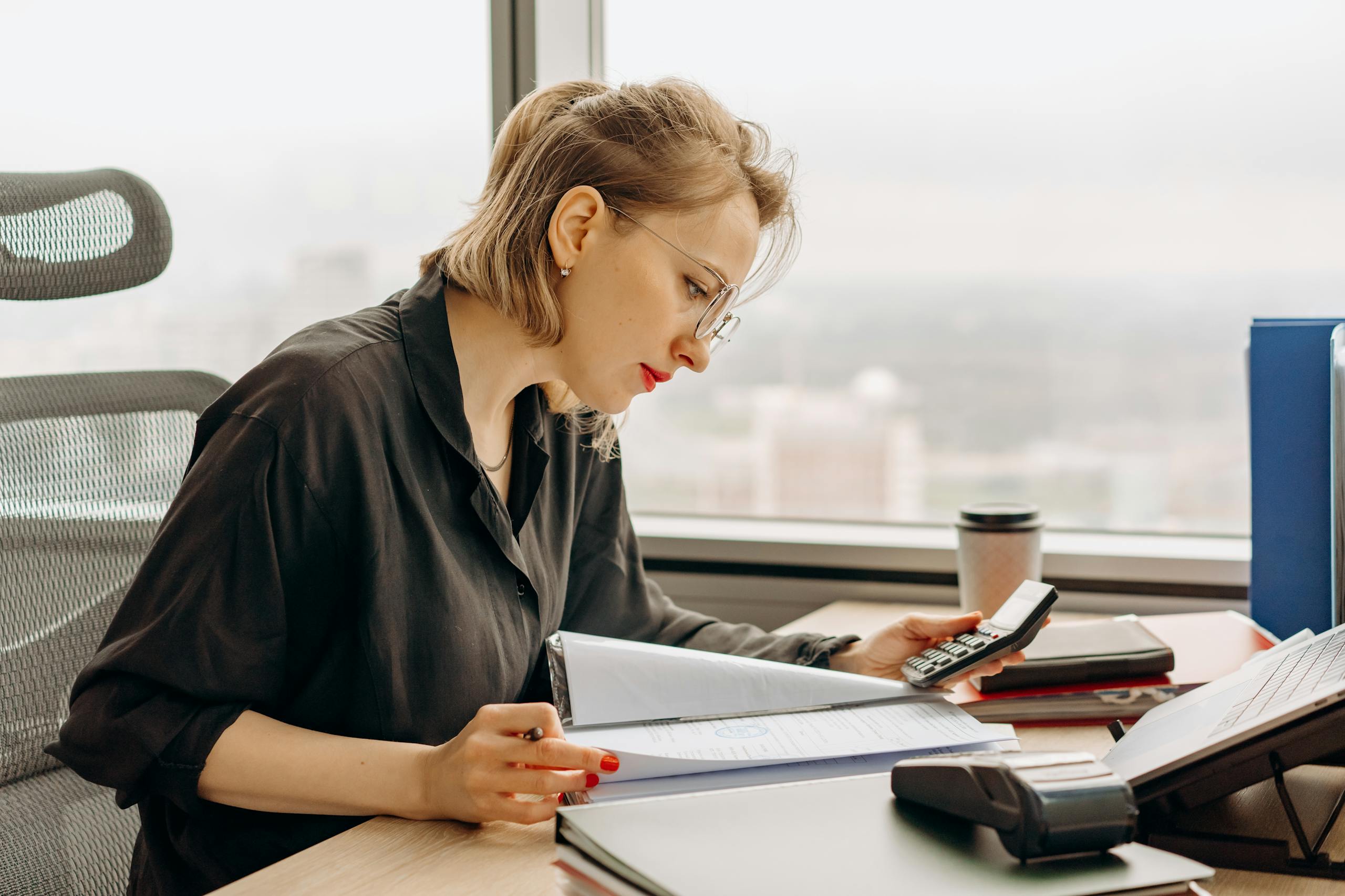 Industries 1 Business Support for Accountants | Zesty Business Essentials. Photo of a woman accountant calculating financial documents at office desk. Accountants